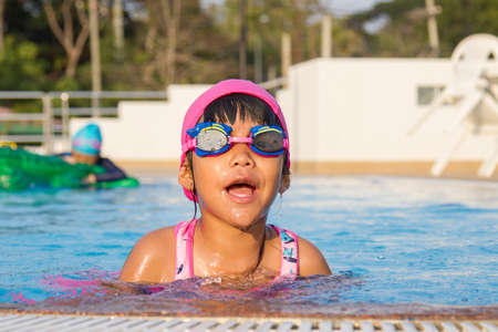 Girl playing with water in the swimming poolの写真素材