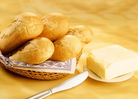 Baguettes in a basket and butter brickの写真素材