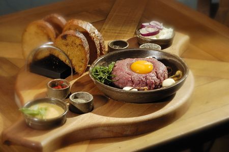 Steak tartar with the rosemary on the wooden trencherの写真素材
