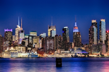 The New York City Uptown w Intrepid sea, air and space museum in the nightの写真素材