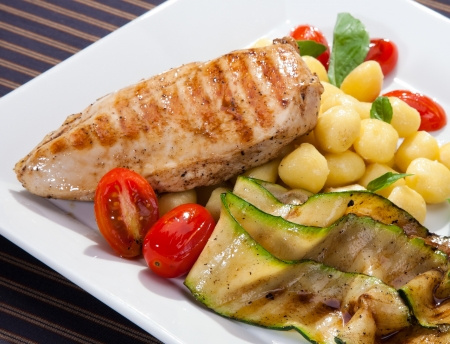 Grilled chicken breast w grilled aubergine and italian dumplingsの写真素材