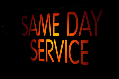 Neon Sign Same Day Service on Black Backgroundの写真素材