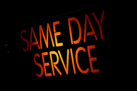 Neon Sign Same Day Service on Black Backgroundの写真素材
