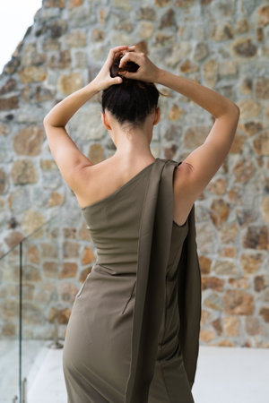 Fashion portrait of beautiful brunette woman posing in stylish evening dress, outdoor, natural daylightの写真素材