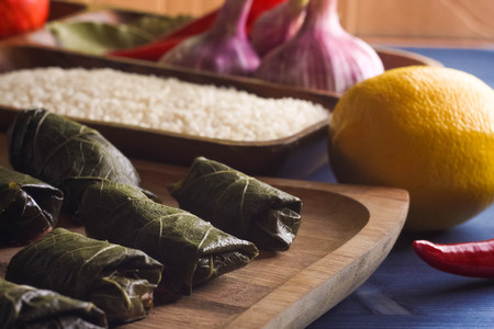 Stuffed delicious dolma with ingredients and lemon on wooden Board on blue backgroundの写真素材