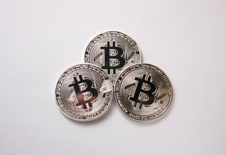 three silver coins bitcoin on a white background
