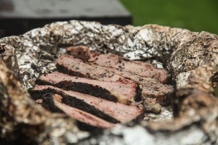 Roast beef in foil in a barbecue closeup