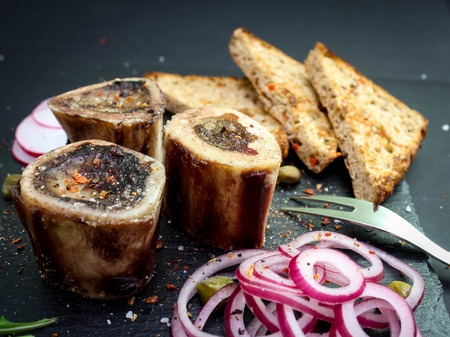 Bone marrow served with pickled onion and toasts on a basalt plateの写真素材