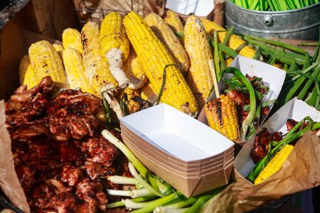 Barbecue spread corn on the cob, steak fillet and chicken kebabs with corn. A side dish prepared during the picnicの写真素材