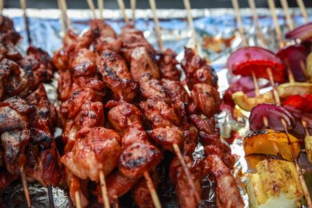 Meat and vegetable kebabs on wooden skewers in a street restaurantの写真素材