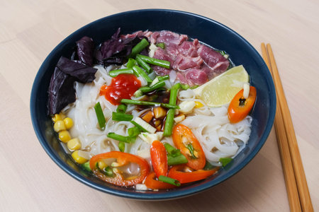 Vietnamese Pho Bo soup with rice noodles, beef and Basil
