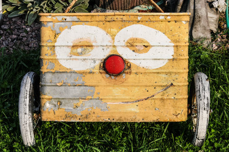 An old garden cart with a funny face painted on it
