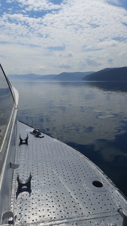 Boatboard and surface of the water sky and clouds