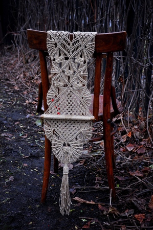 Macrame handmade on a wooden chair in the garden. The background of dyadの写真素材