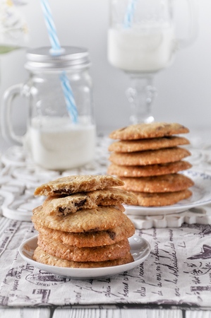 Cookies with sesame and milk chocolate. Glass of smoothies. Glass jars for fruit cocktailsの写真素材