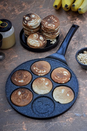 In the kitchen in a frying pan pancakes, fritters with smileysの写真素材
