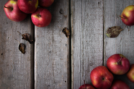 Red fresh apples on a wooden background scatteredの写真素材