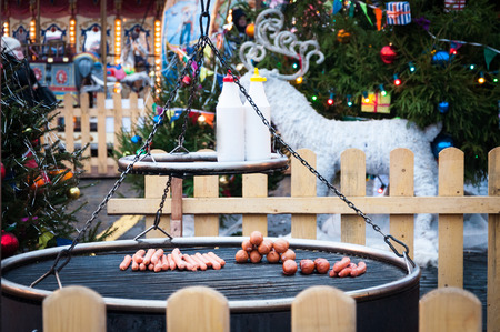 Christmas Market in Red Square, Moscow. Preparation of sausages and sausages on a grill for hot dogsの写真素材