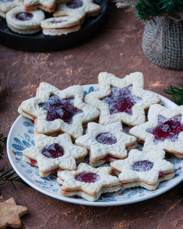 On the dish, almond cookies in the form of stars with strawberry jam. Christmas treatsの写真素材