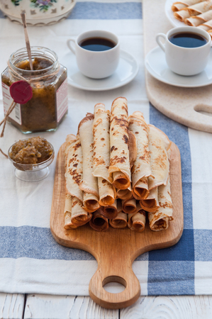 Thin pancakes for breakfast. Maslenitsa. On the table, a dish with pancakes, coffee and jam from feijoaの写真素材