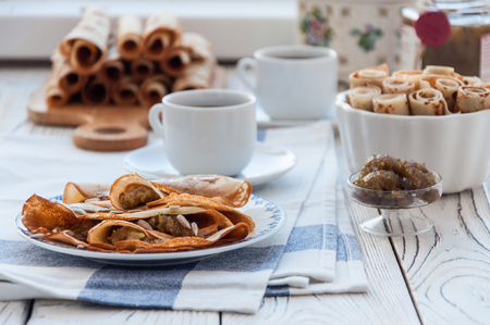 Thin pancakes for breakfast. Maslenitsa. On the table, a dish with pancakes, coffee and jam from feijoaの写真素材
