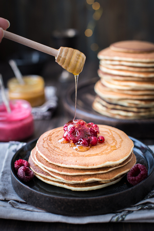 Pancakes with honey, jam and berriesの写真素材