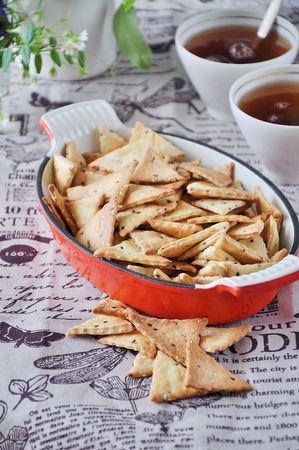 Triangular home made cracker with black and white sesameの写真素材