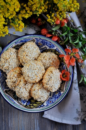 Homemade oat biscuits, cookies with sesame seeds, decorated with spring flowersの写真素材