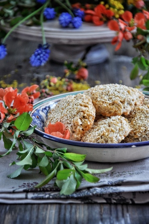 Homemade oat biscuits, cookies with sesame seeds, decorated with spring flowersの写真素材