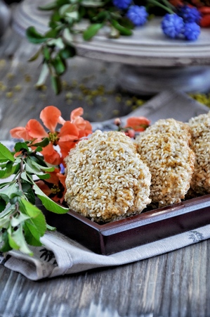 Homemade oat biscuits, cookies with sesame seeds, decorated with spring flowersの写真素材