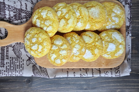 Coconut biscuits tinted with turmeric. On the chopping boardの写真素材