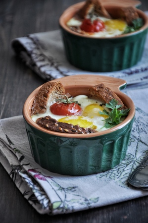 For breakfast, egg with bread and whole tomatoes cherry baked in oven moldsの写真素材