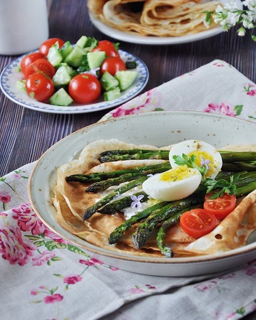 Breakfast of pancakes baked with asparagus with boiled egg and cream cheeseの写真素材