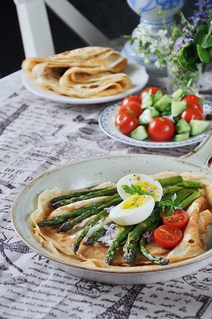 Breakfast of pancakes baked with asparagus with boiled egg and cream cheeseの写真素材