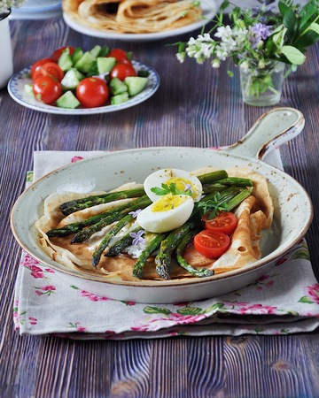Breakfast of pancakes baked with asparagus with boiled egg and cream cheeseの写真素材