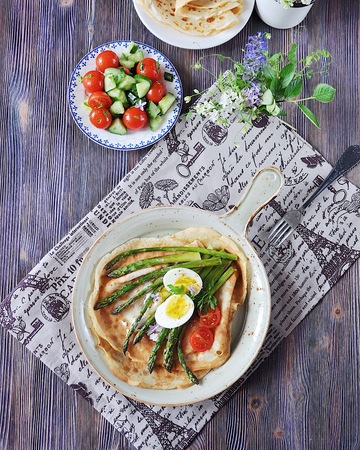 Breakfast of pancakes baked with asparagus with boiled egg and cream cheeseの写真素材
