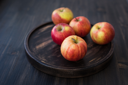 On a wooden stand. Fresh red apples. Wooden backgroundの写真素材