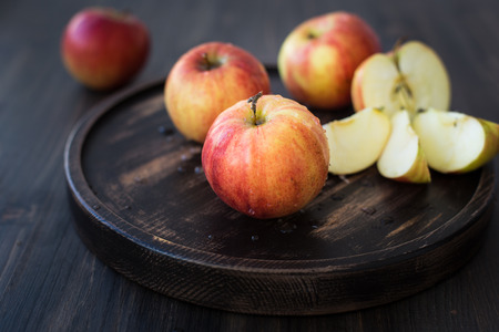 On a wooden stand. Fresh red apples. Wooden backgroundの写真素材