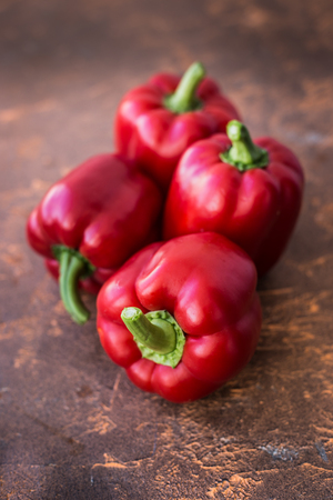 Fresh red bell peppers on a wooden table backgroundの写真素材