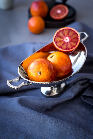 Red oranges in a metal vaseの写真素材