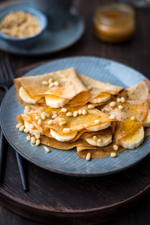 Pancakes with honey, bananas and pine nutsの写真素材