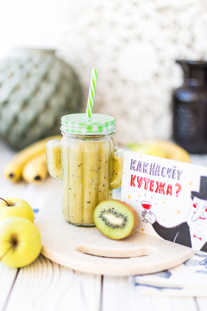 Apple-banana-kiwi smoothie cocktail. On the plate is the inscriptionの写真素材
