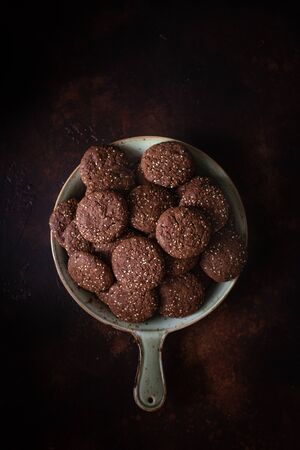 Chocolate cracked cookies with chocolate and sesame seeds. On a ceramic decorative dishの写真素材