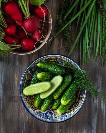 A dish of fresh vegetables, cucumbers and radishes, spring onionsの写真素材
