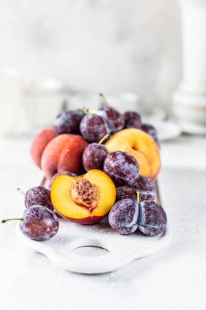 Still life of plums and peaches on a white backgroundの写真素材