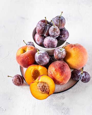 Still life of plums and peaches on a white backgroundの写真素材