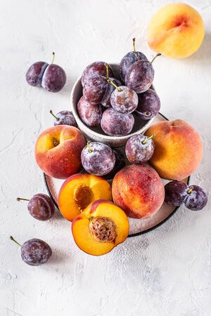 Still life of plums and peaches on a white backgroundの写真素材