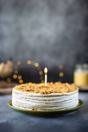 Homemade honey birthday cake with a candle, honey cakeの写真素材