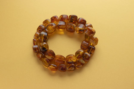 Natural Baltic amber necklace on yellow background. High quality photoの写真素材