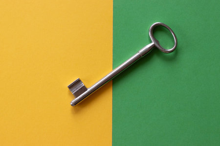 Vintage metal key on yellow and green background.の写真素材